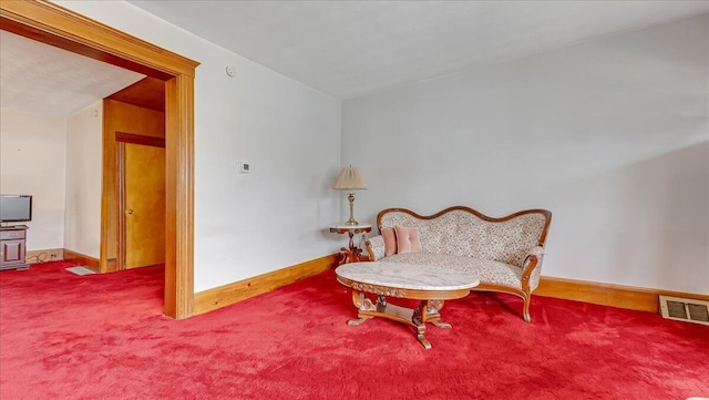 sitting room with visible vents, baseboards, and carpet flooring