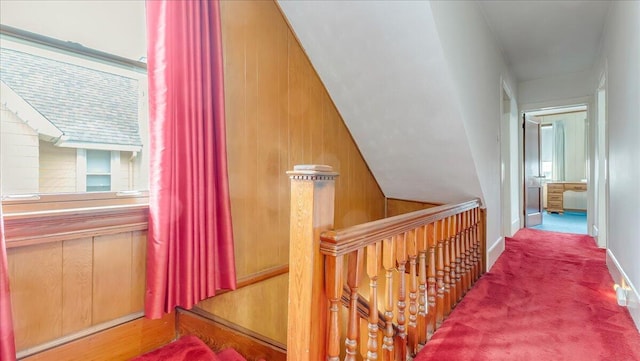 corridor featuring carpet flooring and wood walls