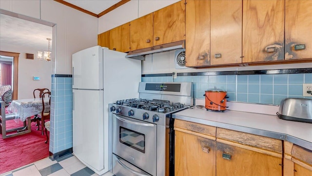 kitchen featuring tasteful backsplash, under cabinet range hood, light floors, ornamental molding, and gas stove