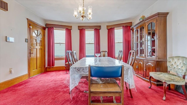 dining space featuring an inviting chandelier, baseboards, and carpet