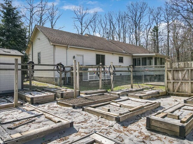 205 Flatbrook Way, Milford, PA 18337 - back of property featuring fence, roof with shingles, a sunroom, and a garden