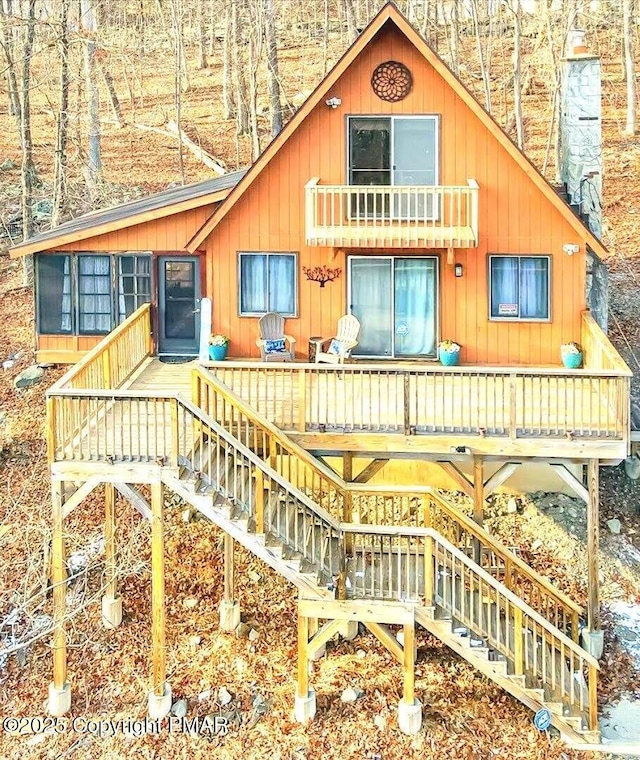 back of house featuring stairs and a chimney