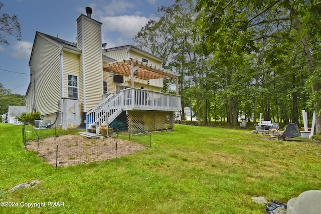 rear view of house featuring a yard, a chimney, central AC, a pergola, and a wooden deck