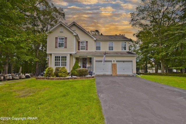 view of front of property with driveway, a front lawn, and an attached garage