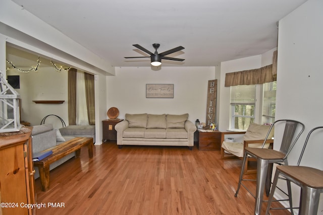 living area with wood finished floors and a ceiling fan