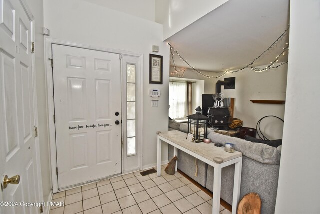 entryway featuring a wood stove and light tile patterned floors