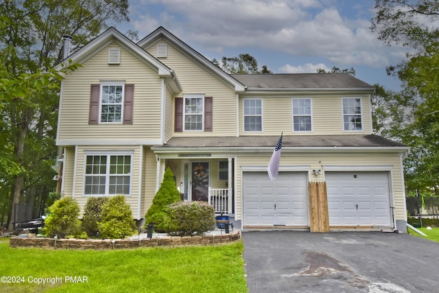 traditional-style house with driveway, a garage, and a front lawn