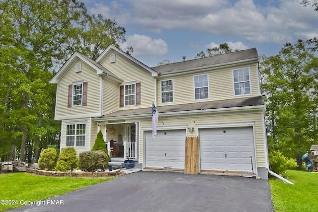 view of property featuring a garage and a front lawn