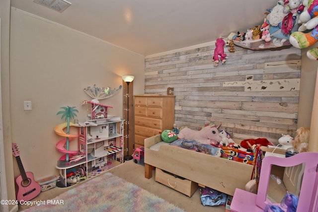 bedroom featuring wooden walls, visible vents, and crown molding