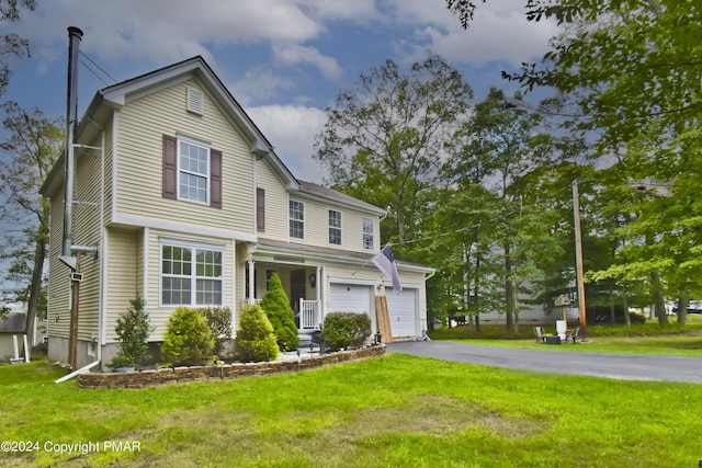 view of front of home with a garage, aphalt driveway, and a front yard