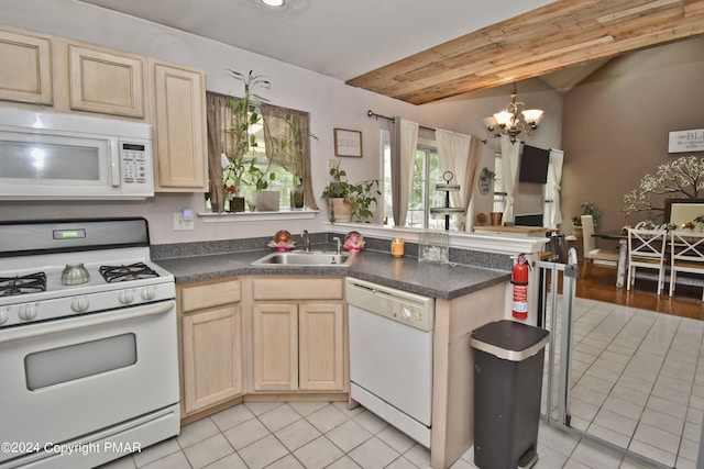 kitchen with a notable chandelier, dark countertops, light brown cabinets, a sink, and white appliances