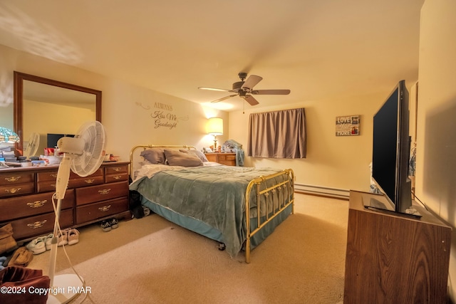 carpeted bedroom with a baseboard heating unit and a ceiling fan