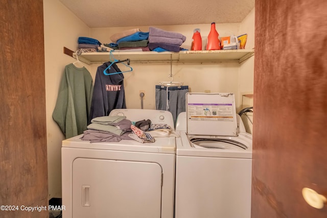 clothes washing area with washing machine and dryer, laundry area, and a textured ceiling