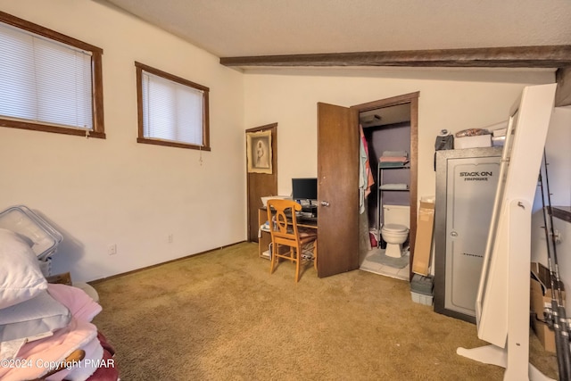 home office with light carpet and vaulted ceiling with beams