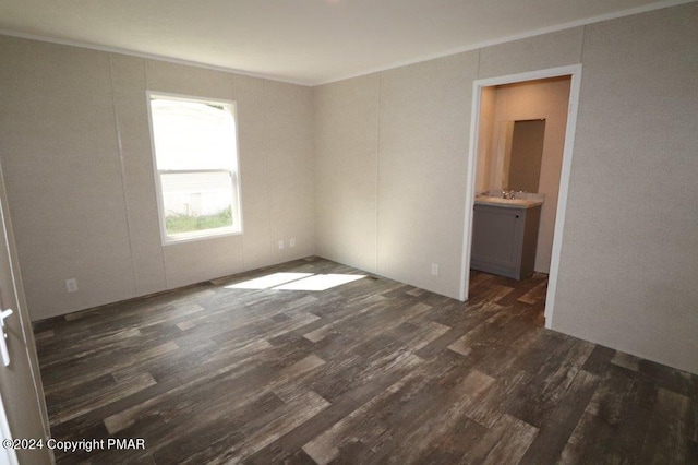 unfurnished room featuring ornamental molding and dark wood finished floors