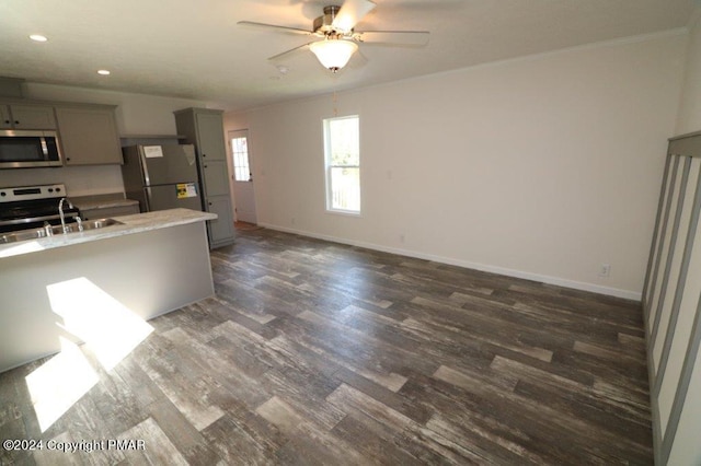 kitchen featuring baseboards, stainless steel appliances, dark wood finished floors, and gray cabinetry