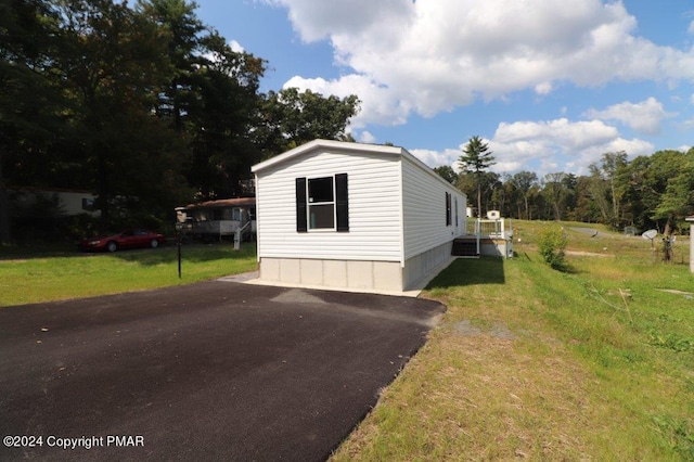 view of side of home with a yard and driveway