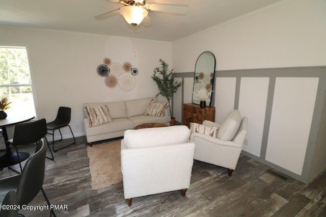 living room featuring baseboards, visible vents, a ceiling fan, dark wood-style floors, and ornamental molding