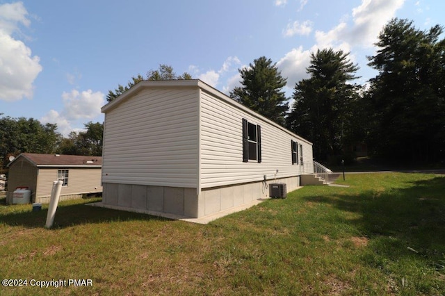 view of side of home featuring a yard and central air condition unit