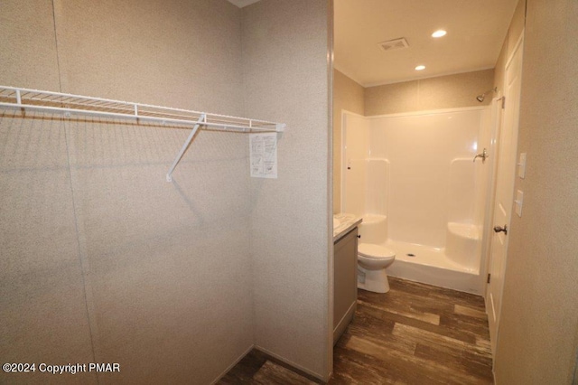 full bath featuring toilet, recessed lighting, wood finished floors, visible vents, and a shower stall