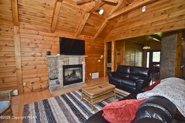 106 Windsor Dr, Lake Ariel, PA 18436 - living area with ceiling fan, wooden walls, a wooden ceiling with exposed beams, wood finished floors, and a fireplace
