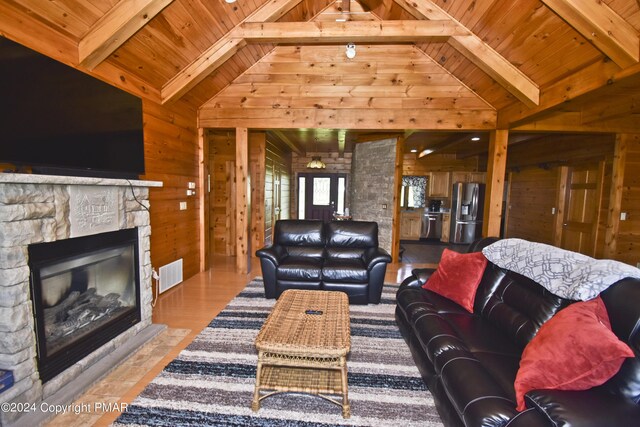106 Windsor Dr, Lake Ariel, PA 18436 - living area with wooden walls, a wooden ceiling with exposed beams, a stone fireplace, and high vaulted ceiling