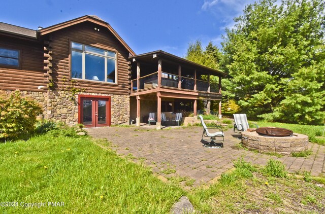 106 Windsor Dr, Lake Ariel, PA 18436 - rear view of house with french doors, an outdoor fire pit, a patio area, and log siding