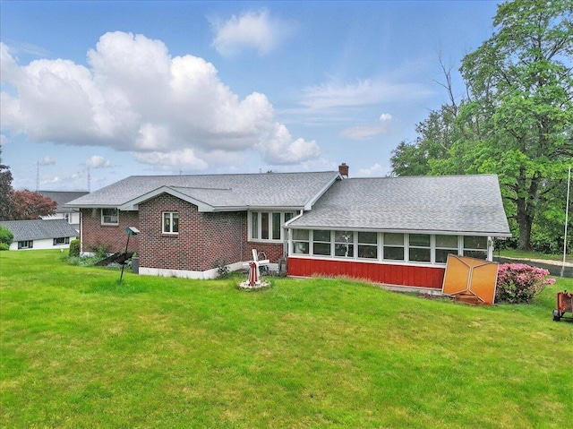 20 Cleveland Ave, East Bangor, PA 18013 - back of house with a lawn, roof with shingles, a chimney, a sunroom, and brick siding