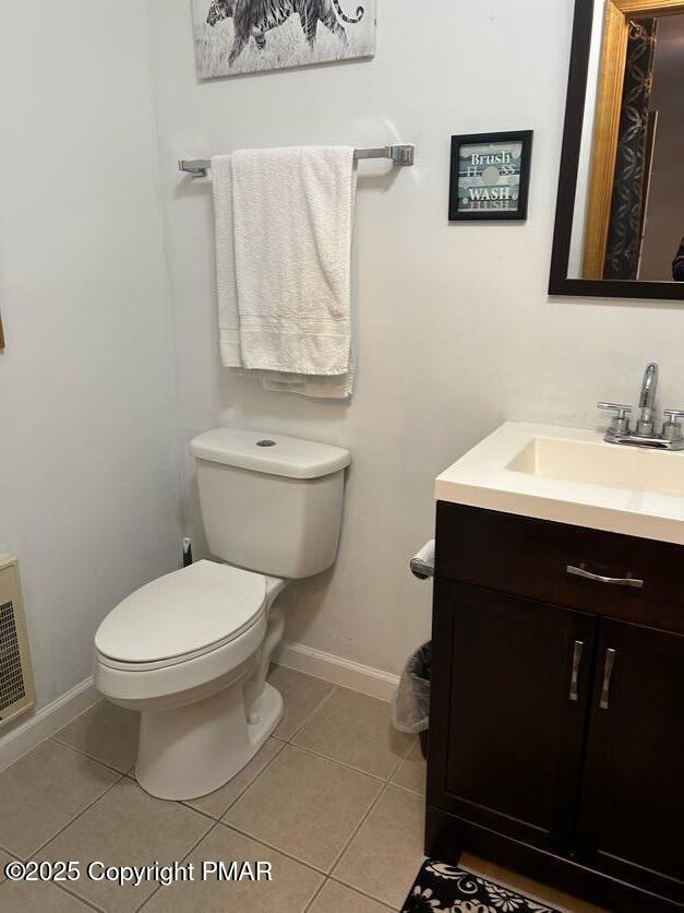 bathroom featuring tile patterned flooring, toilet, vanity, and baseboards