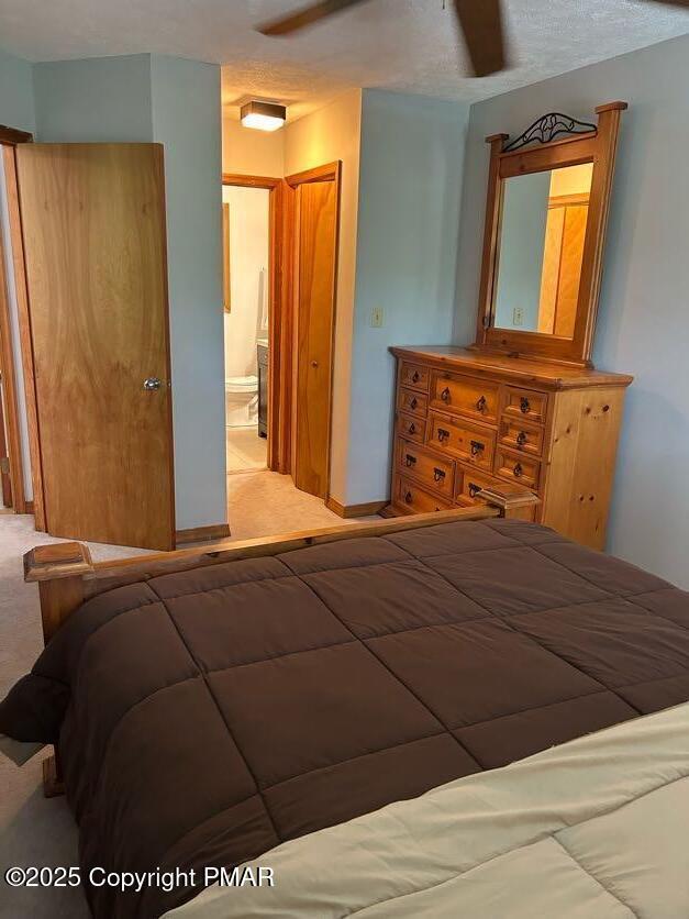 bedroom with light colored carpet and ensuite bath