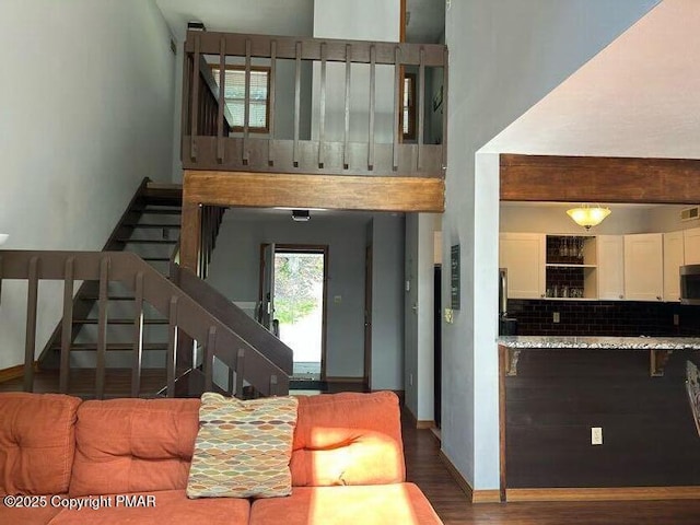 living room with stairway, wood finished floors, and baseboards