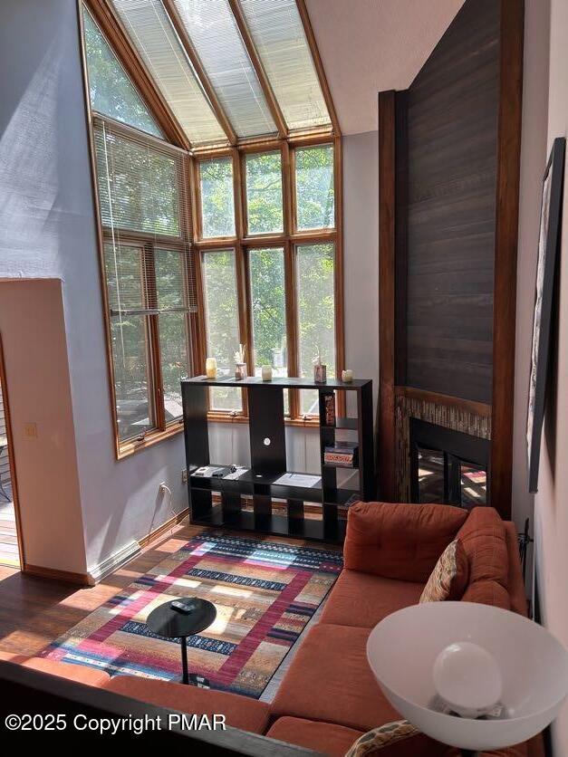 living area with a large fireplace, lofted ceiling, and plenty of natural light