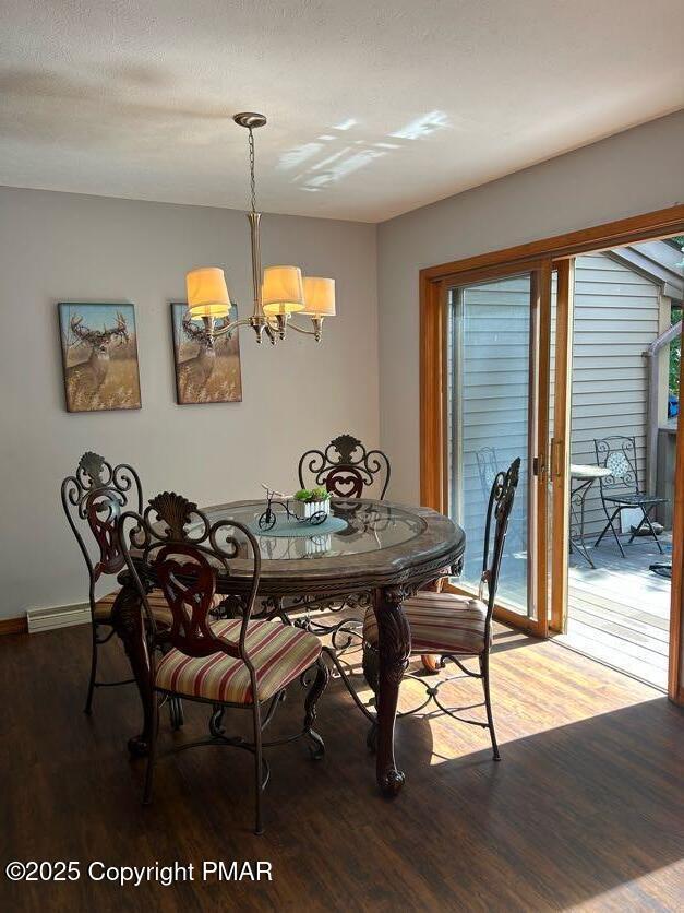 dining space featuring an inviting chandelier and wood finished floors