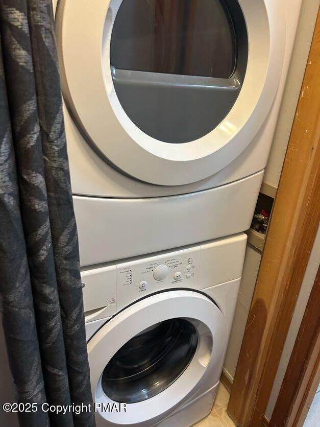 washroom featuring stacked washer and clothes dryer