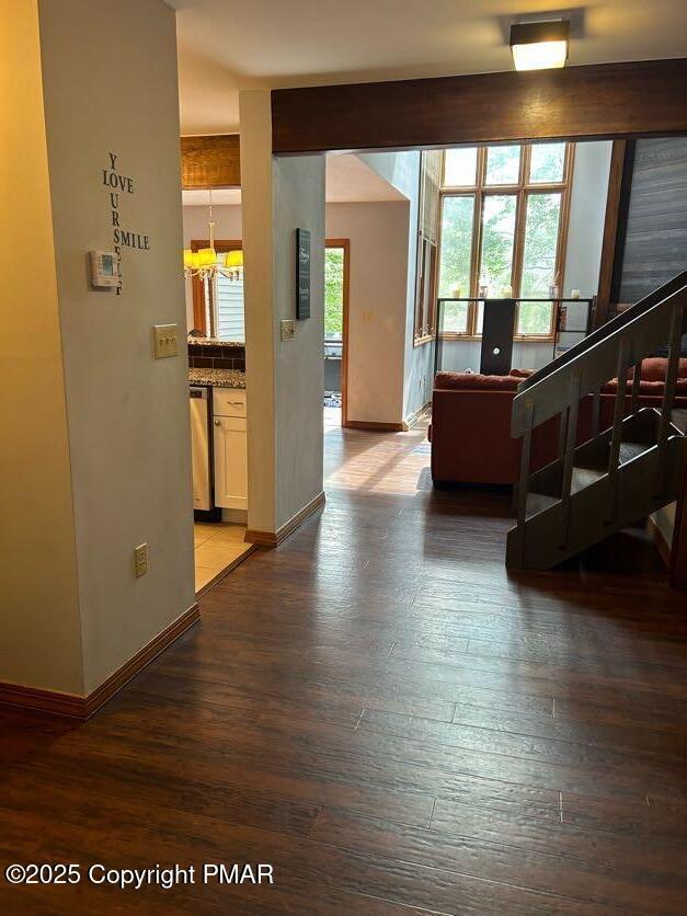 living area with stairs, baseboards, and wood finished floors