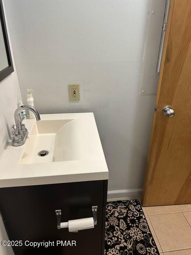 bathroom featuring vanity, baseboards, and tile patterned flooring