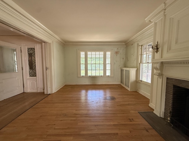 712 Thomas St, Stroudsburg, PA 18360 - unfurnished living room with healthy amount of natural light, a brick fireplace, wood finished floors, crown molding, and baseboards