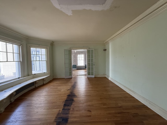 712 Thomas St, Stroudsburg, PA 18360 - empty room with ornamental molding, wood finished floors, baseboards, french doors, and radiator