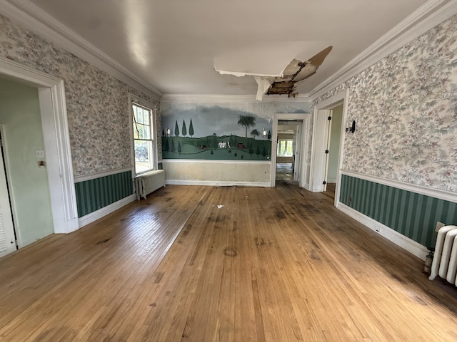 712 Thomas St, Stroudsburg, PA 18360 - unfurnished room with radiator heating unit, wainscoting, wallpapered walls, wood-type flooring, and ornamental molding