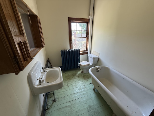 712 Thomas St, Stroudsburg, PA 18360 - full bath featuring radiator, a freestanding tub, toilet, hardwood / wood-style flooring, and a sink