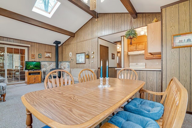 144 Beech Ln, Pocono Lake, PA 18347 - dining space with a wood stove, wood walls, light colored carpet, and a skylight