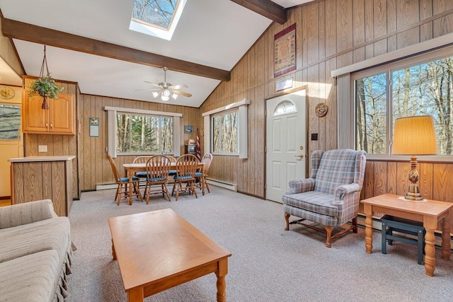 144 Beech Ln, Pocono Lake, PA 18347 - living room with wooden walls, a skylight, light colored carpet, a ceiling fan, and a baseboard radiator