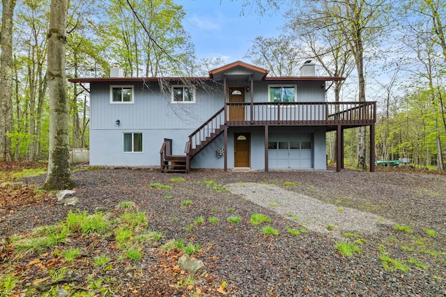 19 Conservancy Ct, Gouldsboro, PA 18424 - rear view of property featuring a chimney, stairs, gravel driveway, and a garage