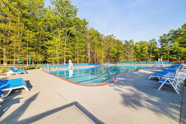 19 Conservancy Ct, Gouldsboro, PA 18424 - community pool featuring a patio area, fence, and a wooded view