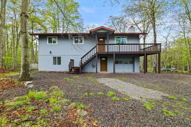 19 Conservancy Ct, Gouldsboro, PA 18424 - rear view of property featuring a chimney, stairs, gravel driveway, and a garage
