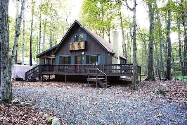 view of front of property with a forest view and a wooden deck