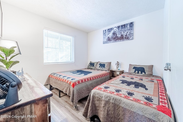 bedroom featuring a textured ceiling and wood finished floors