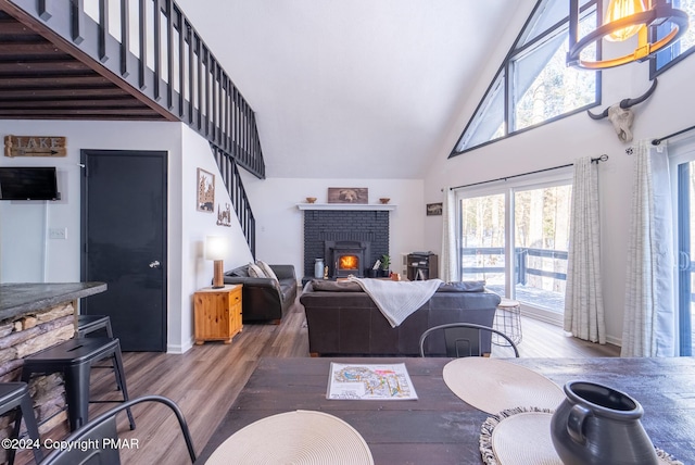 living room with baseboards, a fireplace, high vaulted ceiling, and wood finished floors