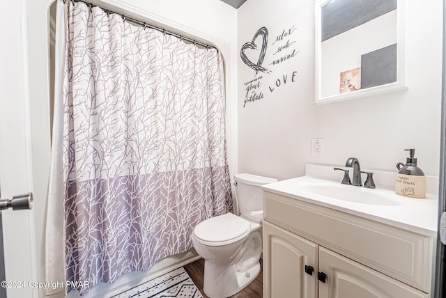 bathroom featuring toilet, curtained shower, wood finished floors, and vanity