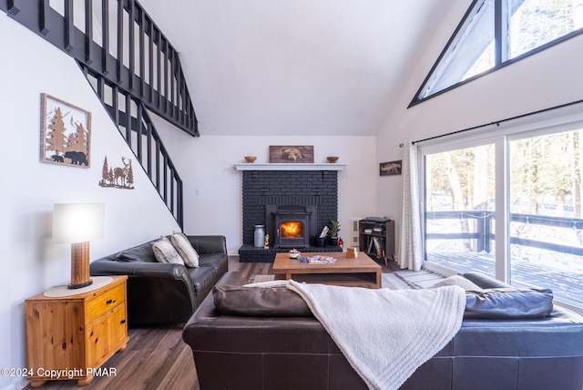 living room with high vaulted ceiling, stairs, and wood finished floors